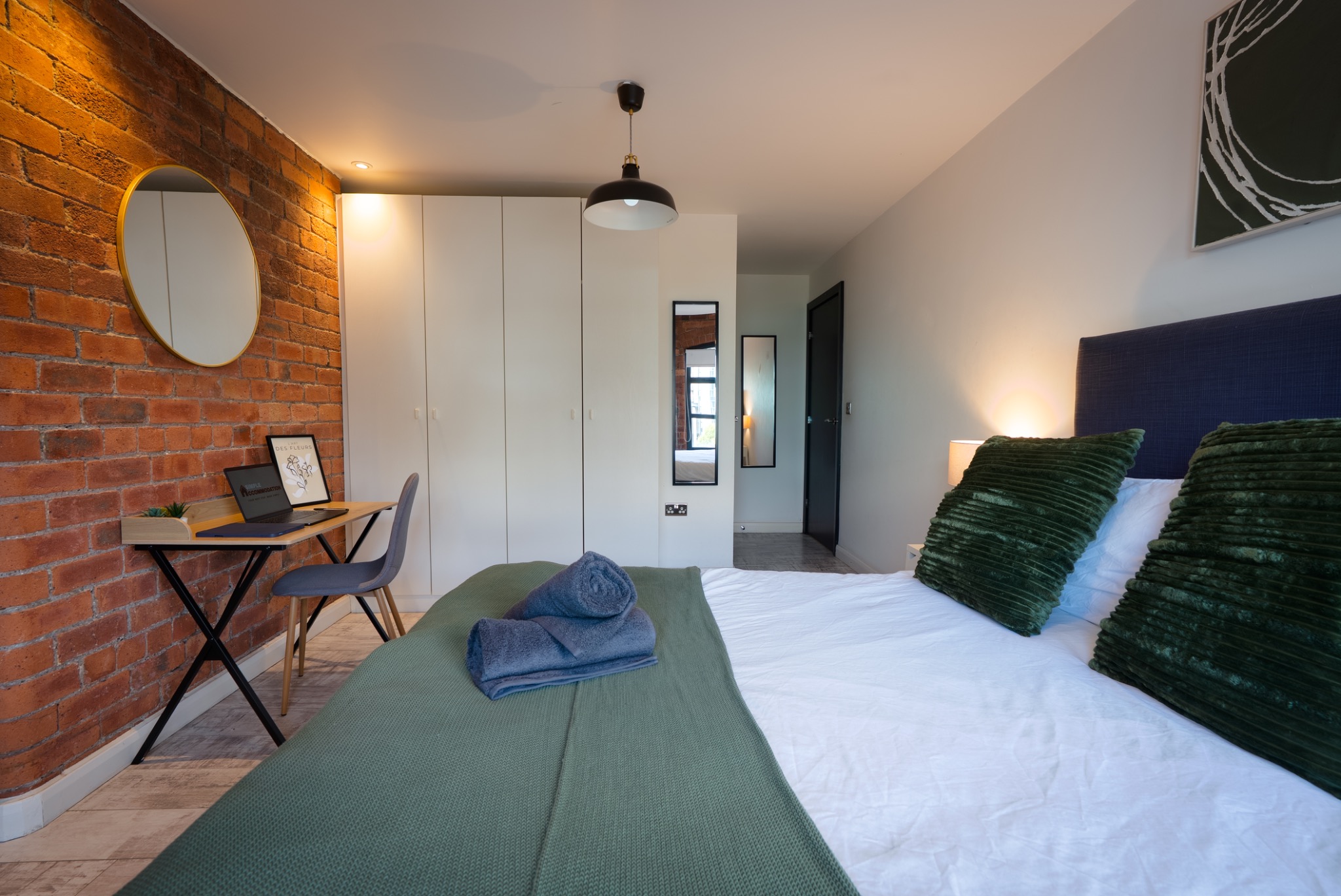 Bedroom with desk and exposed brick