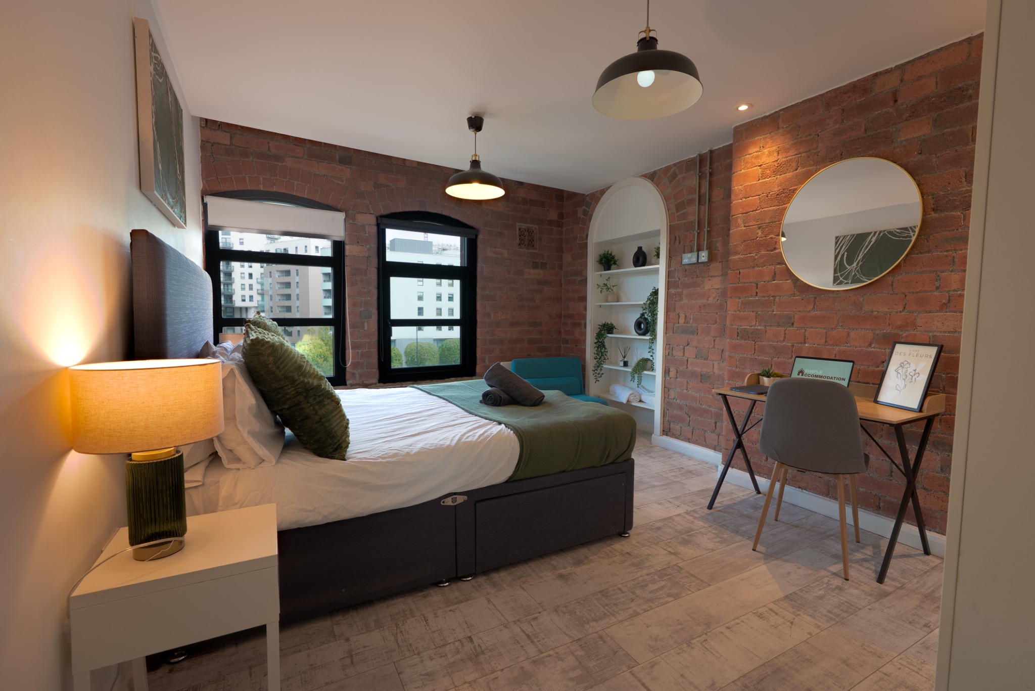 Bedroom with seating area and exposed brick